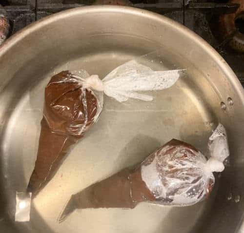 Disposable Piping Bags filled with chocolate in hot water.